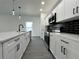 Galley style kitchen with black backsplash, quartz countertops, and gray wood-look flooring at 955 Redwood St, Daytona Beach, FL 32117
