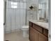 Well-lit bathroom featuring white shower curtain, granite-topped vanity, and updated fixtures at 1079 Lincolnshire Dr, Deland, FL 32724