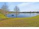 Scenic view of the serene pond with grassy banks and distant homes, offering a peaceful atmosphere at 1079 Lincolnshire Dr, Deland, FL 32724