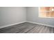 Bedroom with grey wood flooring and neutral paint, features a window with wood-look blinds at 100 Sweetgum Woods Ct # 10C, Deltona, FL 32725