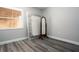 Bedroom with grey wood flooring and neutral paint features a window and floor mirror at 100 Sweetgum Woods Ct # 10C, Deltona, FL 32725