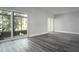 Bright living room featuring modern gray floors, sliding glass doors, and ample natural light at 100 Sweetgum Woods Ct # 10C, Deltona, FL 32725