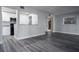 Open floorplan showcasing modern living room with gray floors flowing into the updated kitchen at 100 Sweetgum Woods Ct # 10C, Deltona, FL 32725