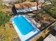Aerial view of the backyard featuring a sparkling blue pool and a brick outdoor fireplace at 1002 Charles St, Port Orange, FL 32129