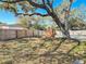 Fenced backyard with lush trees, brick grill and swimming pool at 1002 Charles St, Port Orange, FL 32129