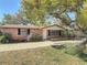 Charming brick home with a well-maintained front yard, mature trees, and brick paved driveway at 1002 Charles St, Port Orange, FL 32129