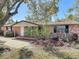 Charming brick home with a well-maintained front yard featuring mature trees and landscaped beds at 1002 Charles St, Port Orange, FL 32129