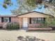Charming brick home featuring a well-maintained yard with mature trees, front porch, and brick pavers at 1002 Charles St, Port Orange, FL 32129