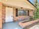 Charming brick home exterior featuring a front porch with brick planter, white door, and window with shutters at 1002 Charles St, Port Orange, FL 32129