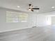 Bright and spacious living room featuring updated laminate flooring and modern ceiling fan at 1002 Charles St, Port Orange, FL 32129