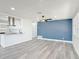Open concept living room featuring new laminate flooring and a pop of blue wall paneling at 1002 Charles St, Port Orange, FL 32129