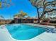Backyard view with pool, brick house, outdoor cooking feature, and mature shade tree at 1002 Charles St, Port Orange, FL 32129