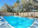Backyard swimming pool with clear blue water, surrounded by a wooden privacy fence and mature trees at 1002 Charles St, Port Orange, FL 32129