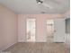 Spacious bedroom with pale pink walls, wood-look floors, and two open doorways at 102 Underbrush Trl, Port Orange, FL 32128