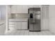 Bright kitchen featuring stainless steel refrigerator, white cabinets, and tile flooring at 102 Underbrush Trl, Port Orange, FL 32128