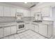 Clean kitchen with white cabinets, tile backsplash, stainless steel sink, and included appliances at 102 Underbrush Trl, Port Orange, FL 32128