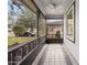View of screened porch featuring decorative tile flooring and ceiling fan at 102 Underbrush Trl, Port Orange, FL 32128