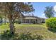 Back of home with screened in pool, and large backyard and trees at 1058 W Seagate Dr, Deltona, FL 32725