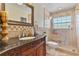 Bathroom with travertine tile, vanity, and glass walk-in shower at 1058 W Seagate Dr, Deltona, FL 32725