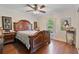 Elegant bedroom featuring hardwood floors, an ornate wooden bed frame and a ceiling fan at 1058 W Seagate Dr, Deltona, FL 32725