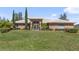 Sprawling home with a lush lawn, manicured landscaping, and a brick facade under a blue sky at 1058 W Seagate Dr, Deltona, FL 32725