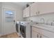 Functional laundry room with white cabinets, sink, washer, and dryer at 1058 W Seagate Dr, Deltona, FL 32725