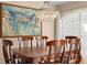 Close up on dining table with dark wood chairs and view of modern chandelier at 1062 Golf View Estates Dr, Orange City, FL 32763