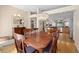 Bright dining room with a wood table, upholstered chairs, modern chandelier and view to the kitchen at 1062 Golf View Estates Dr, Orange City, FL 32763