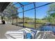 Serene water view from the spacious, screened lanai featuring comfortable lounge seating, grill, and an inviting atmosphere at 1062 Golf View Estates Dr, Orange City, FL 32763