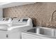 Close up of laundry room with front loading washer and dryer and custom tile backsplash at 1062 Golf View Estates Dr, Orange City, FL 32763