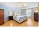 Calming main bedroom is complete with wood floors, accent lighting, and neutral furniture at 1062 Golf View Estates Dr, Orange City, FL 32763