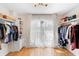 Bright walk-in closet with custom closet organizers and hardwood floors at 1062 Golf View Estates Dr, Orange City, FL 32763