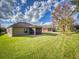 Wide backyard featuring a screened-in porch, green lawn and view of the neighborhood at 107 Gladesdown Ct, Deland, FL 32724