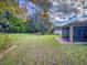 Large backyard with lush lawn and view of the home's screened lanai at 107 Gladesdown Ct, Deland, FL 32724