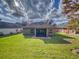 Exterior rear view of the home with a spacious backyard at 107 Gladesdown Ct, Deland, FL 32724