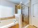 Bright bathroom featuring a soaking tub, glass shower, and tiled walls at 107 Gladesdown Ct, Deland, FL 32724