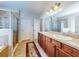 This bathroom features a walk-in shower, double vanity, and neutral tile at 107 Gladesdown Ct, Deland, FL 32724
