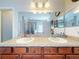 Bathroom with dual sinks, granite countertop, and a large mirror at 107 Gladesdown Ct, Deland, FL 32724
