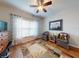 Cozy bedroom featuring wood floors, a ceiling fan, and comfortable seating area with natural light at 107 Gladesdown Ct, Deland, FL 32724