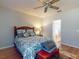 Bedroom with wood-look floors, ceiling fan, and doorway to the bathroom at 107 Gladesdown Ct, Deland, FL 32724