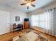 Bright bedroom with wood floors, a ceiling fan, and ample natural light from a large window at 107 Gladesdown Ct, Deland, FL 32724