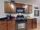 Kitchen featuring rich wood cabinets, a black gas range, and black granite countertops at 107 Gladesdown Ct, Deland, FL 32724