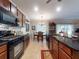 Well-lit kitchen with black appliances, wood cabinets, tile floors and a view to a charming dining area at 107 Gladesdown Ct, Deland, FL 32724