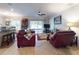 Bright living room with tile floors and ceiling fan, seamlessly connects to kitchen and screened porch at 107 Gladesdown Ct, Deland, FL 32724