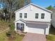 Aerial view of charming home with attached garage, green yard, and surrounding mature trees at 1088 Happy Forest Loop, Deland, FL 32720