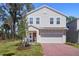 Charming two-story home with a red brick driveway and well-manicured lawn and attached garage at 1088 Happy Forest Loop, Deland, FL 32720