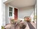 Charming front porch with seating area, including chairs, a table, and a bench at 1088 Happy Forest Loop, Deland, FL 32720