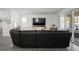 Bright living room with a large sofa, TV, and access to the outdoor patio at 1088 Happy Forest Loop, Deland, FL 32720