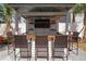 This covered outdoor kitchen bar has seating for three, TV, and is ideal for backyard entertaining at 1088 Happy Forest Loop, Deland, FL 32720