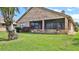 Backyard showcases a brick home with a screened patio and pretty landscaping at 111 Brown Crane Ct, Daytona Beach, FL 32119